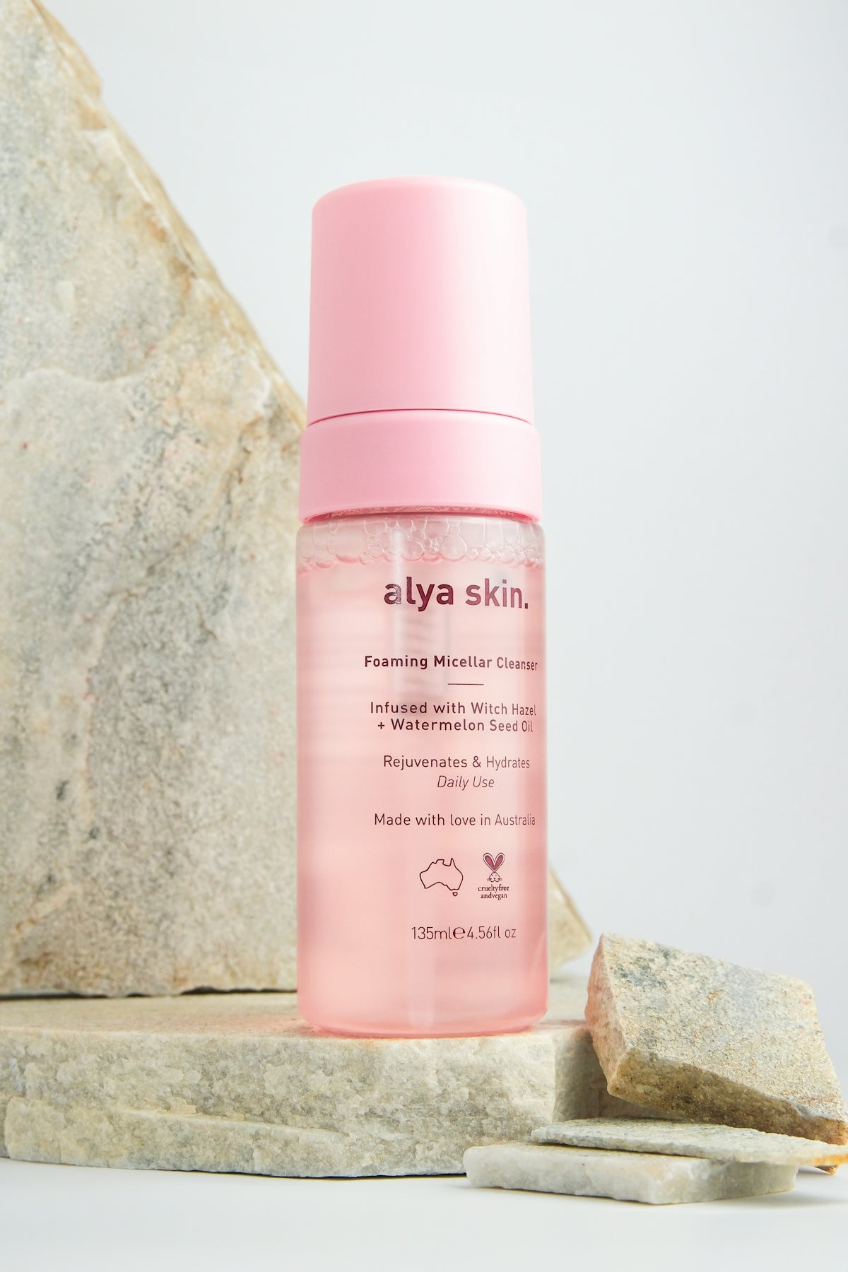 a close up of a bottle of makeup on a rock